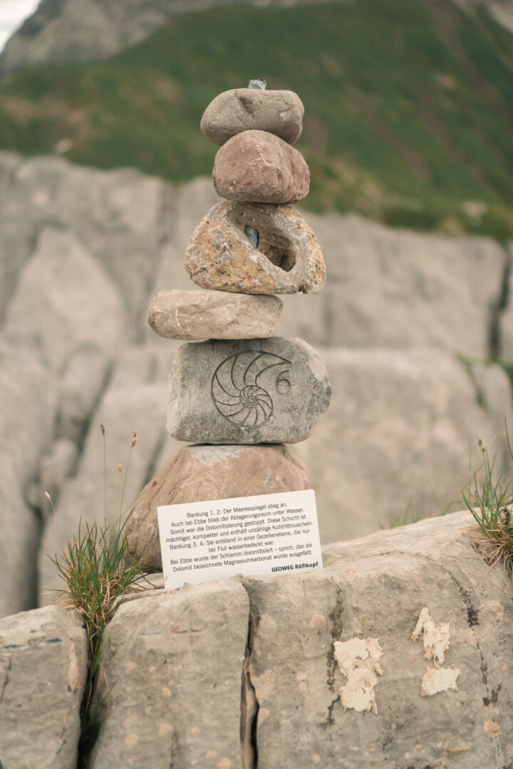 Aufeinander balancierte Steine mit dem Symbol eines Fossils.