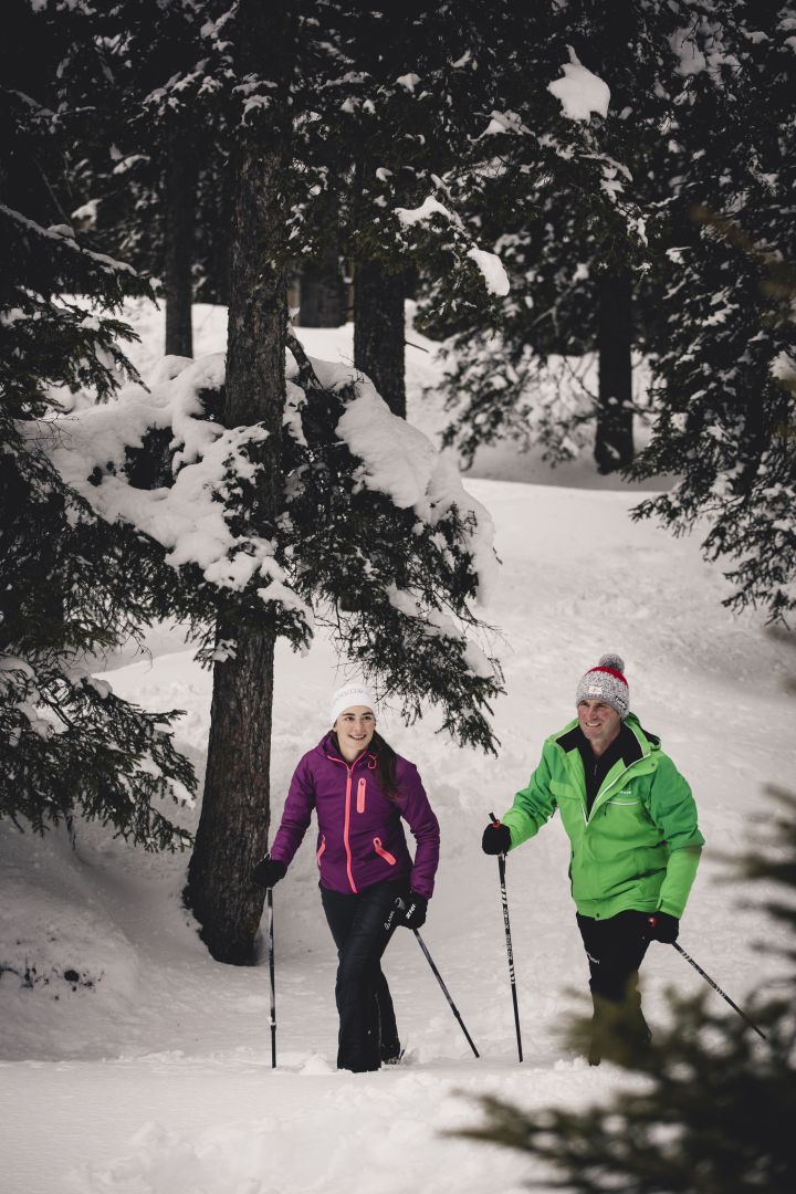 zwei Personen wandern mit ihren Schneeschuhen durch die Winterlandschaft von Lech Zürs am Arlberg