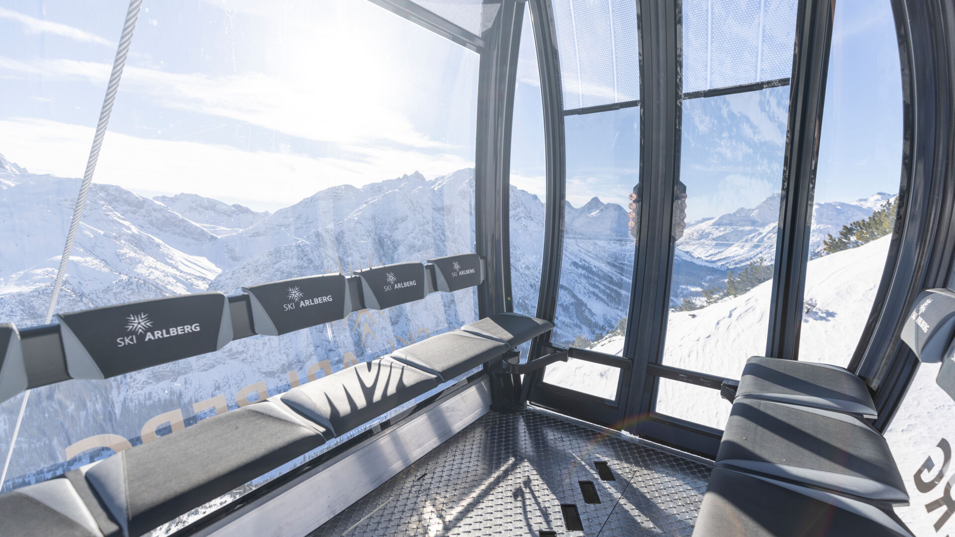 Blick auf das Interieur der Zugerbergbahn im Winter mit sonnigen, verschneiten Bergen im Hintergrund