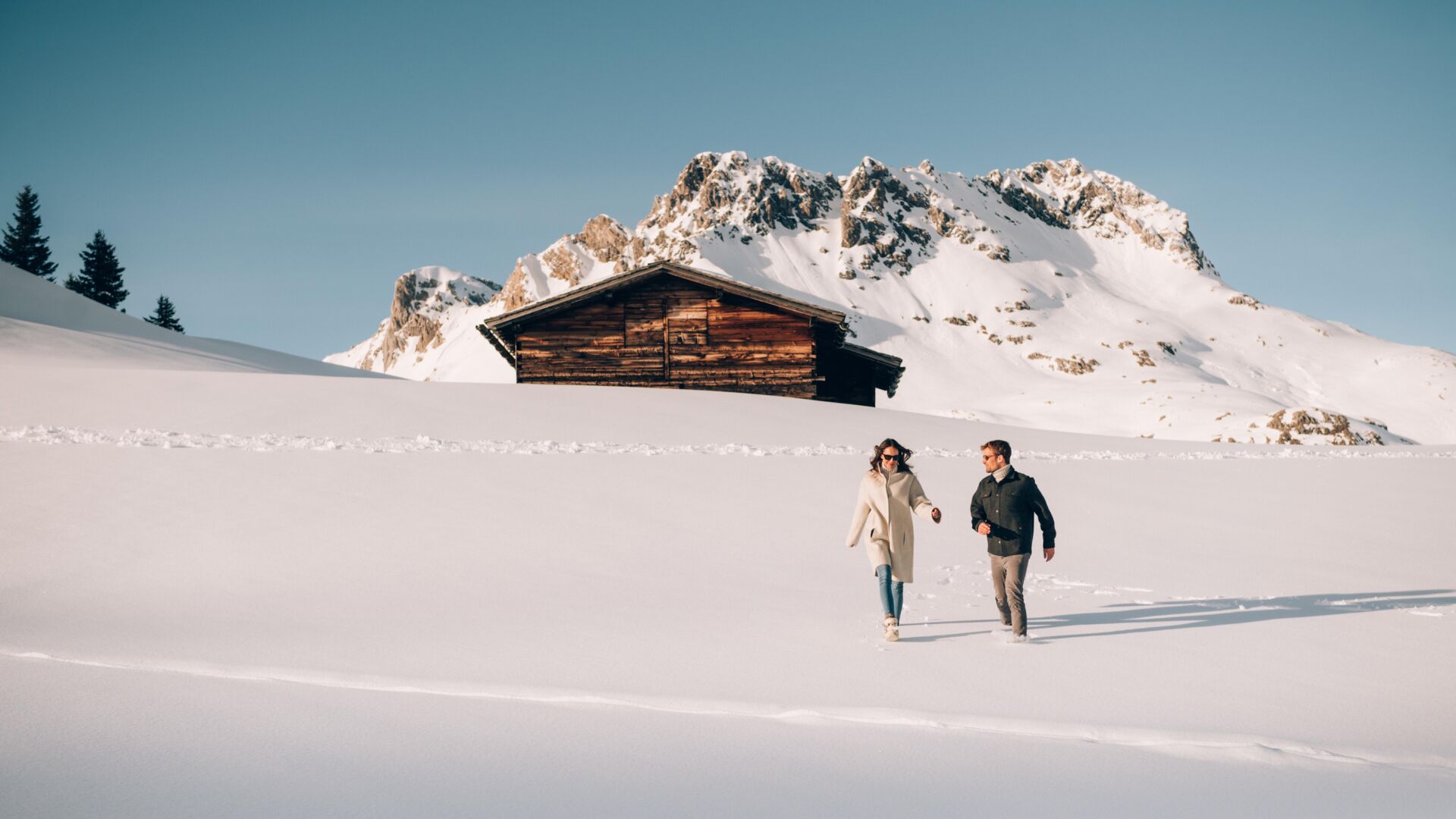 zwei Personen gehen durch den Schnee beim Winterwandern in Oberlech