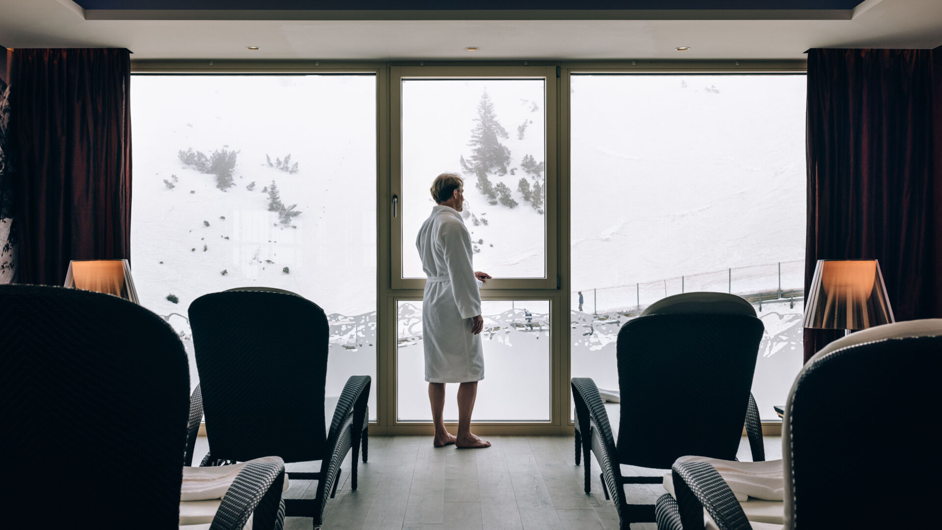 A man gazing at the winter landscape view from the spa area