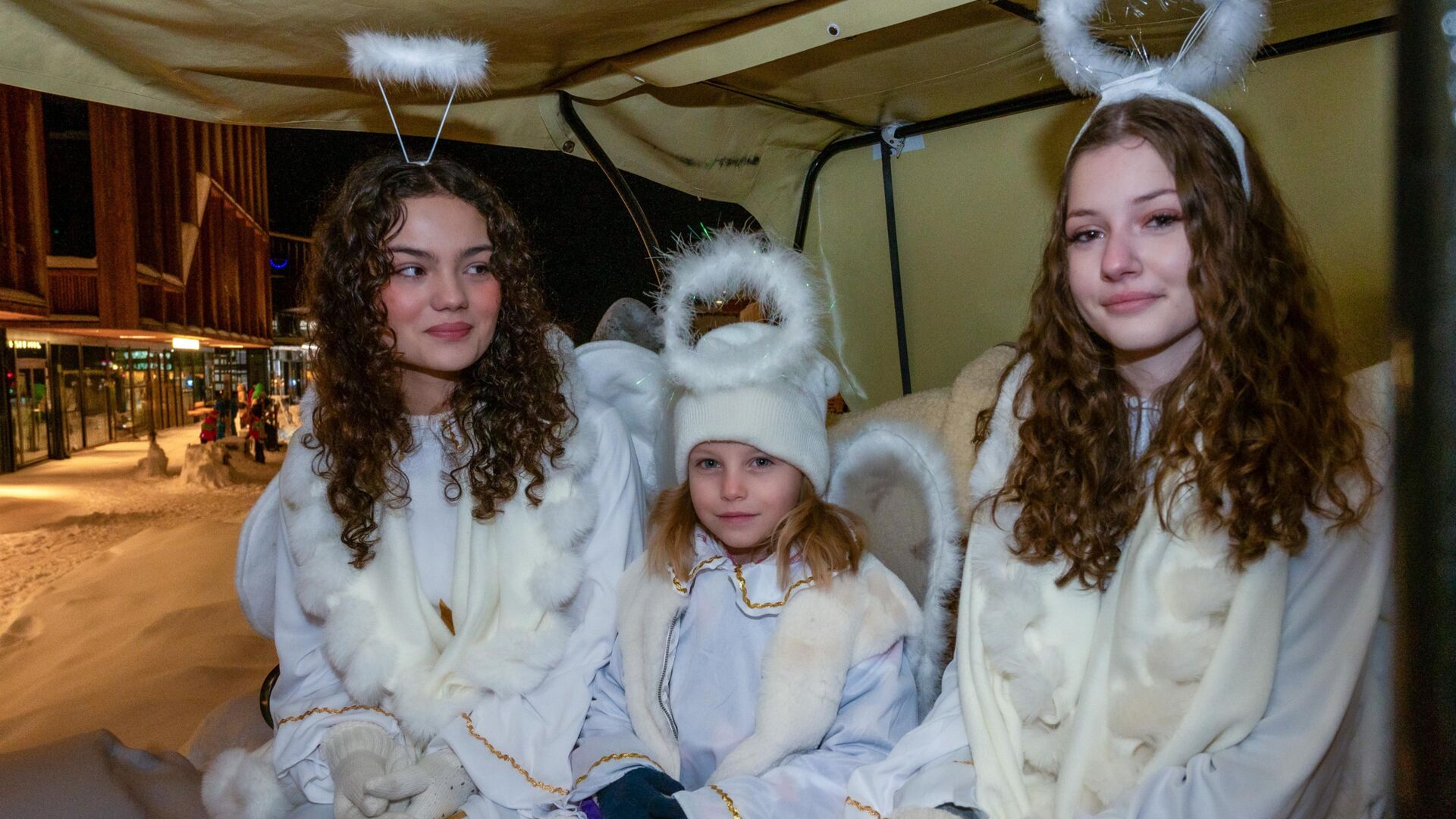 Drei verkleidete Christkinder lachen in die Kamera