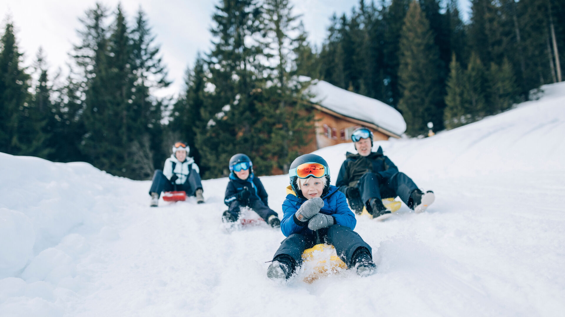 eine Familie rodelt über die Rodelbahn in Lech Zürs mit dem Zipfelbob hinunter