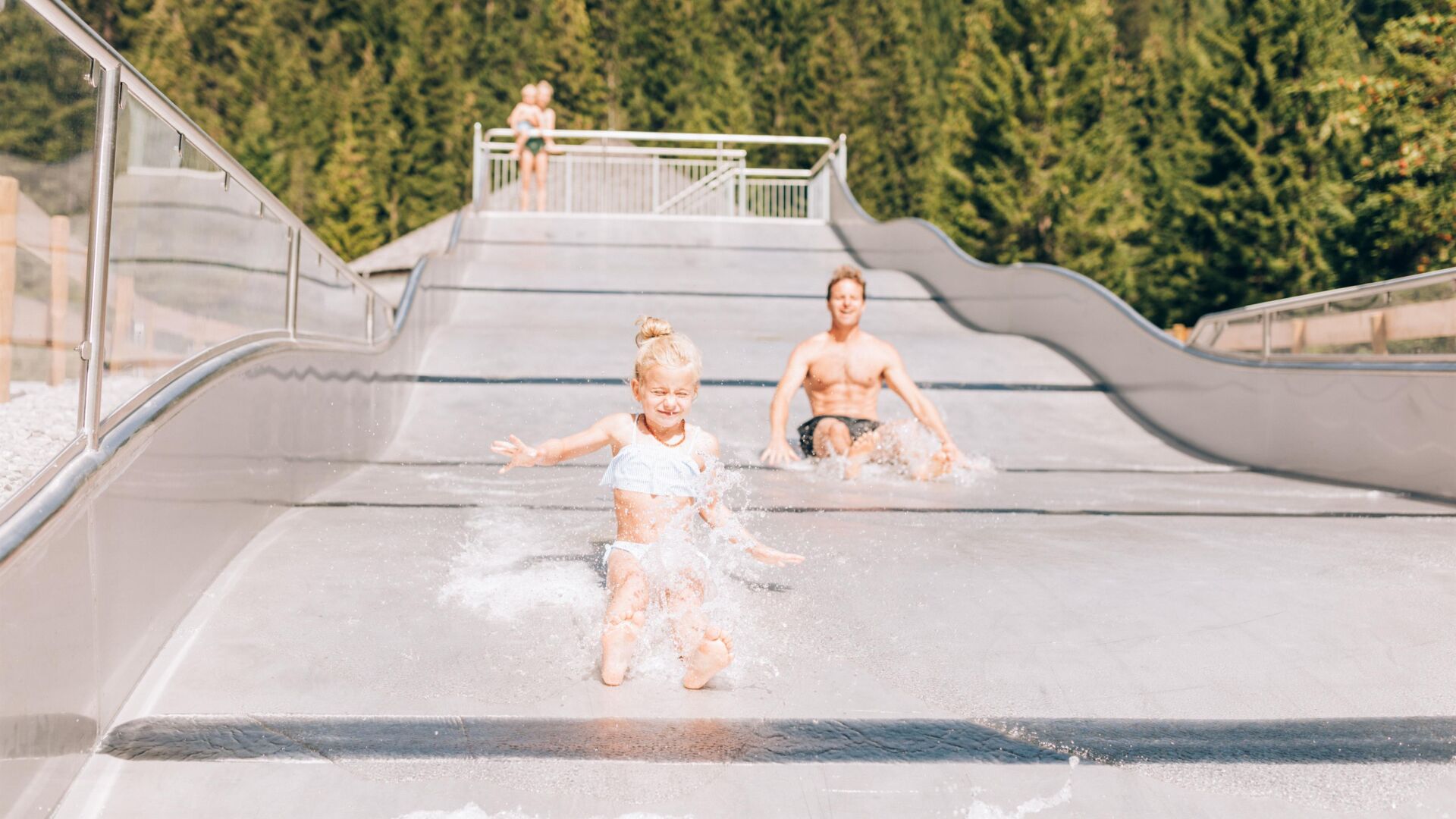 Zwei Kinder rutschen auf der Wasserrutsche