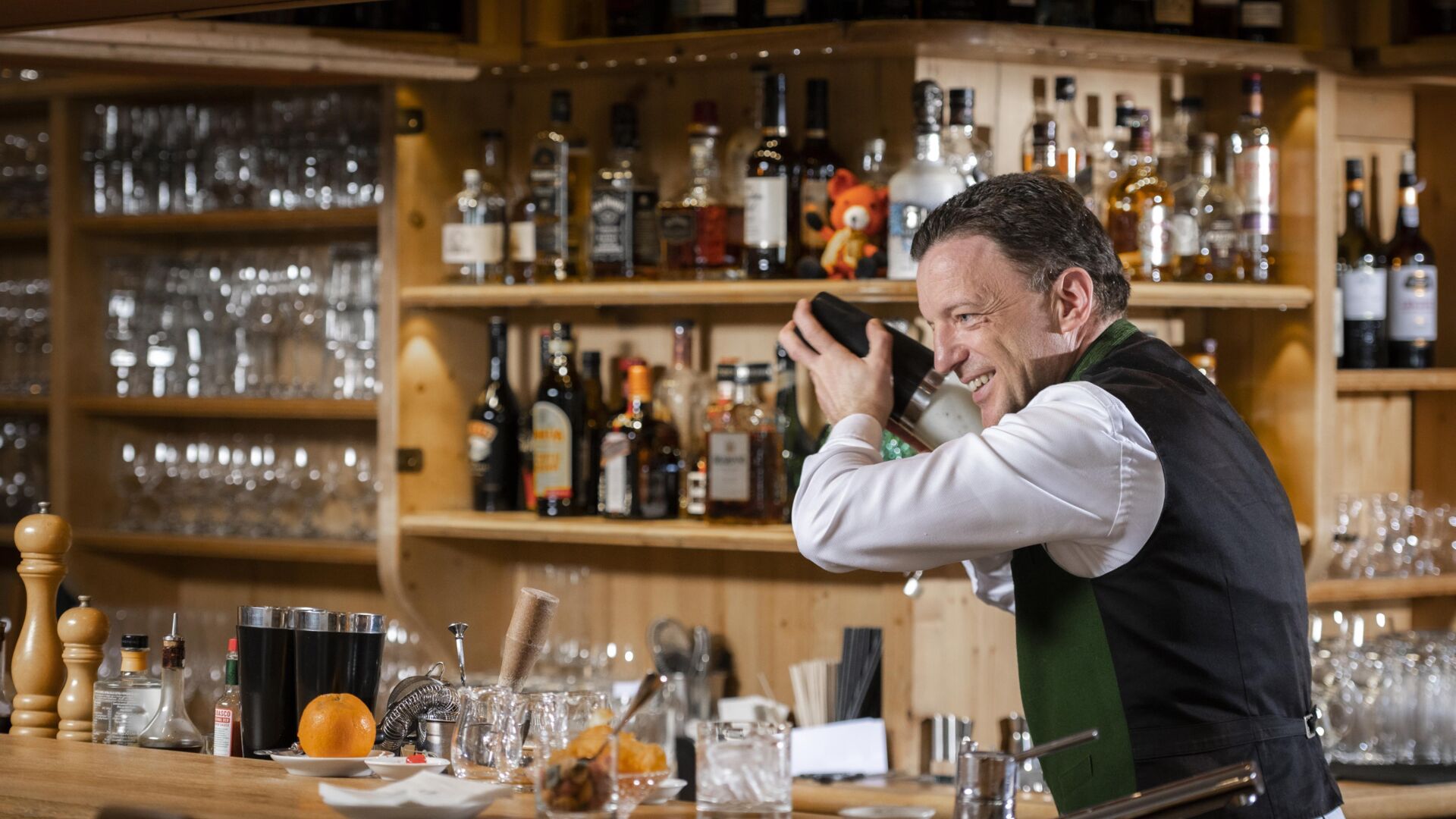 Ein Barkeeper hinter der Theke beim Cocktail shake