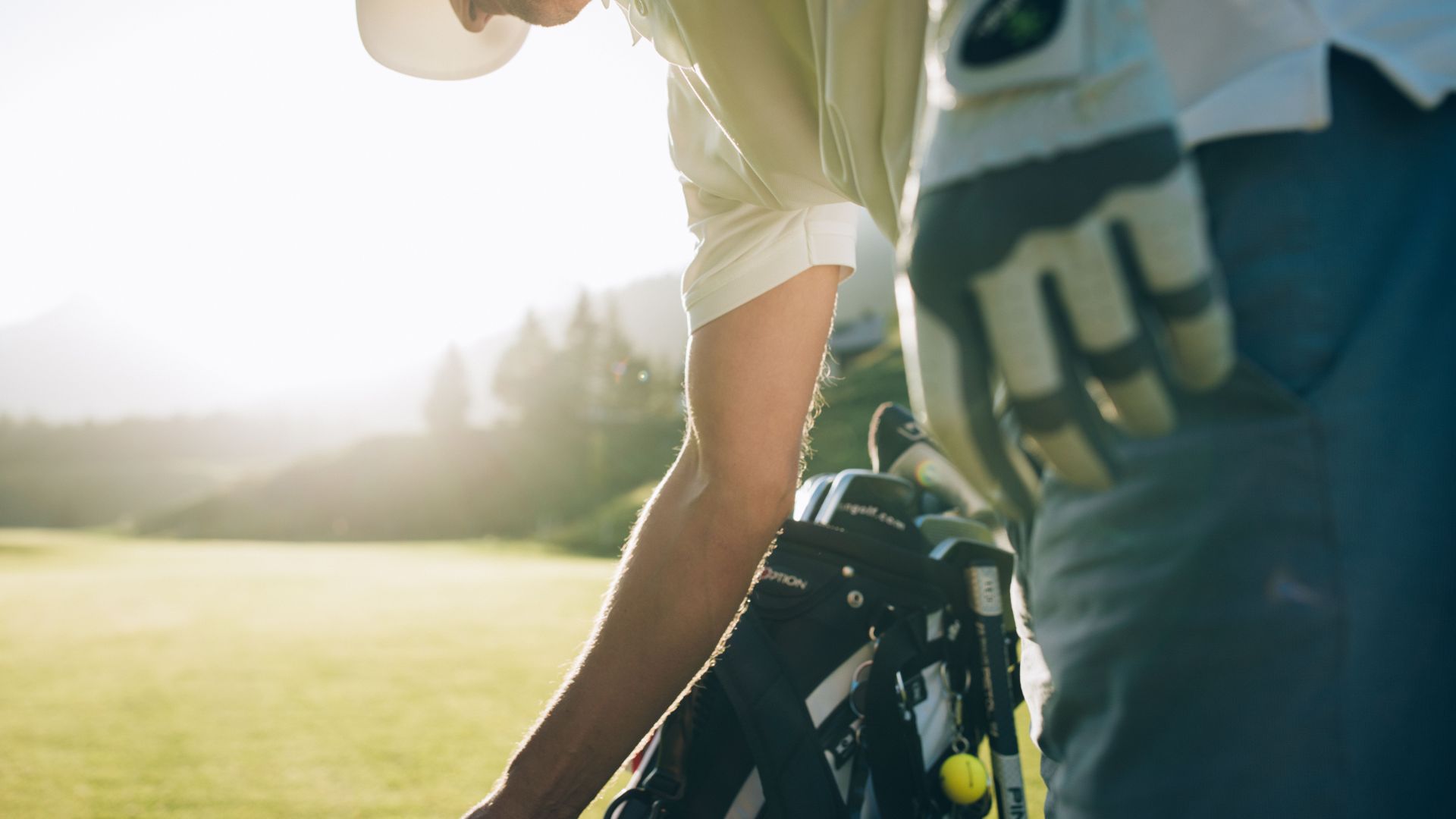 Golfer steht bei seinem Caddy am Golfplatz