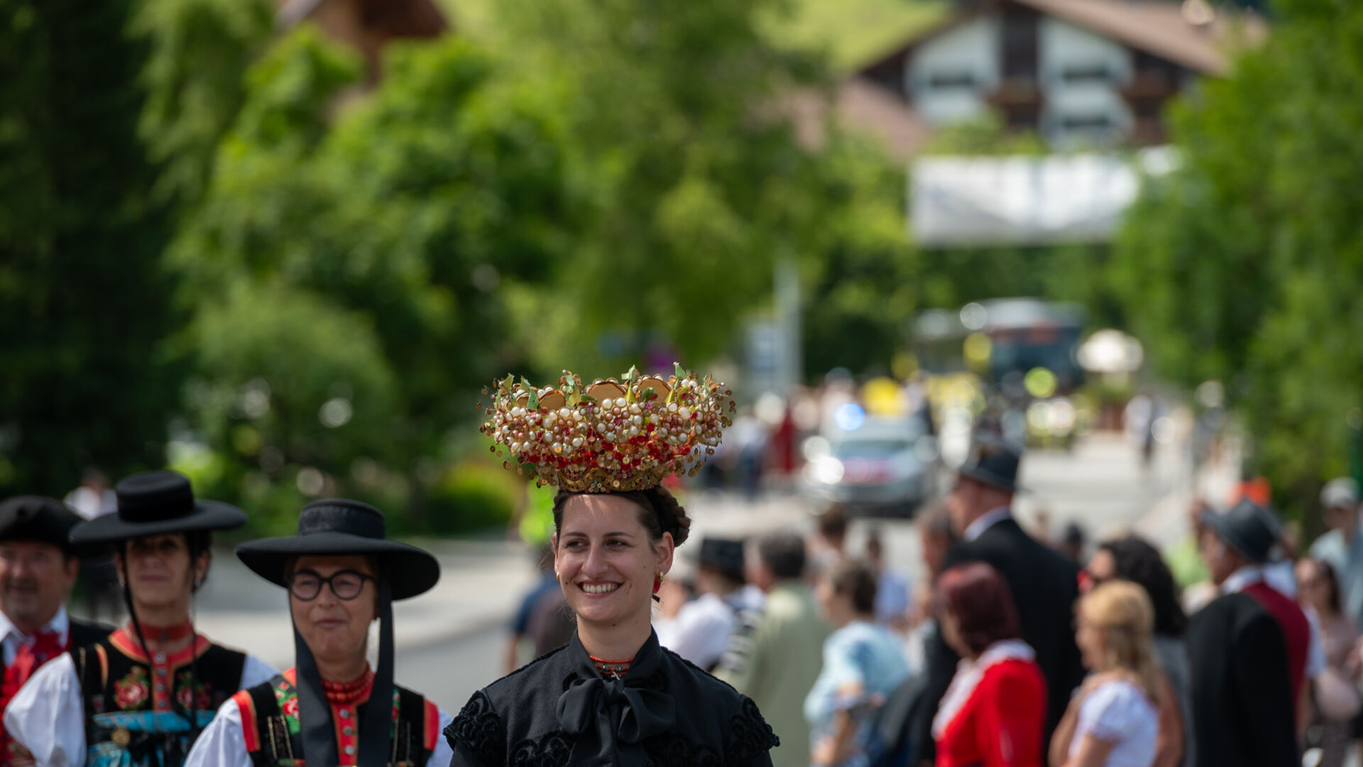 Teilnehmer:innen mit spezieller Tracht und Hüten die am Walsertreffen beim Umzug teilnehmen