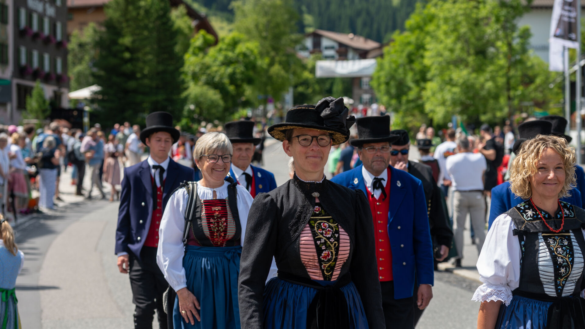 Teilnehmer:innen in traditioneller Tracht die am Umzug vom Walsertreffen teilnehmen