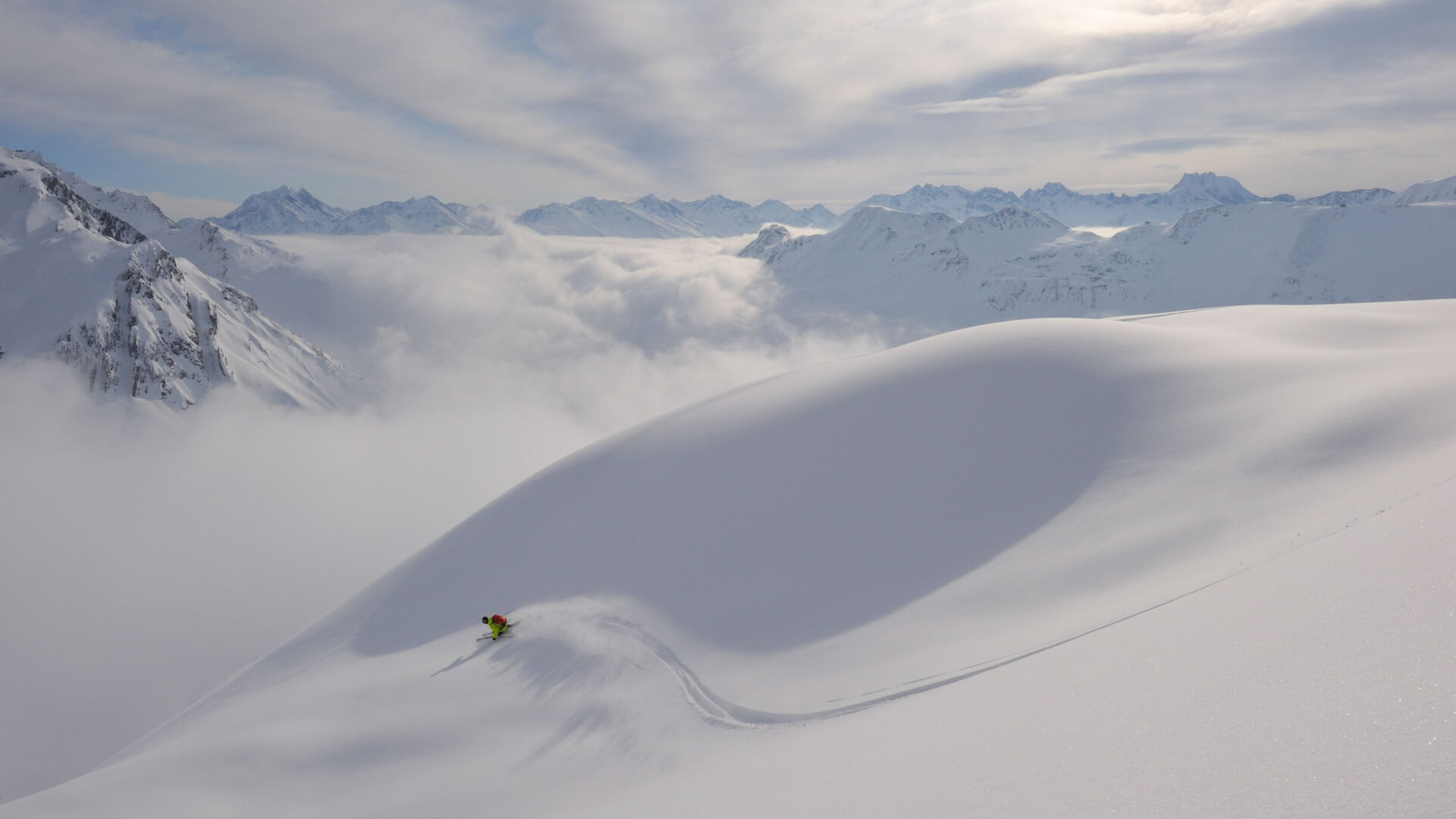 Skifahrer fährt eine Linkskurve in Pulverschnee