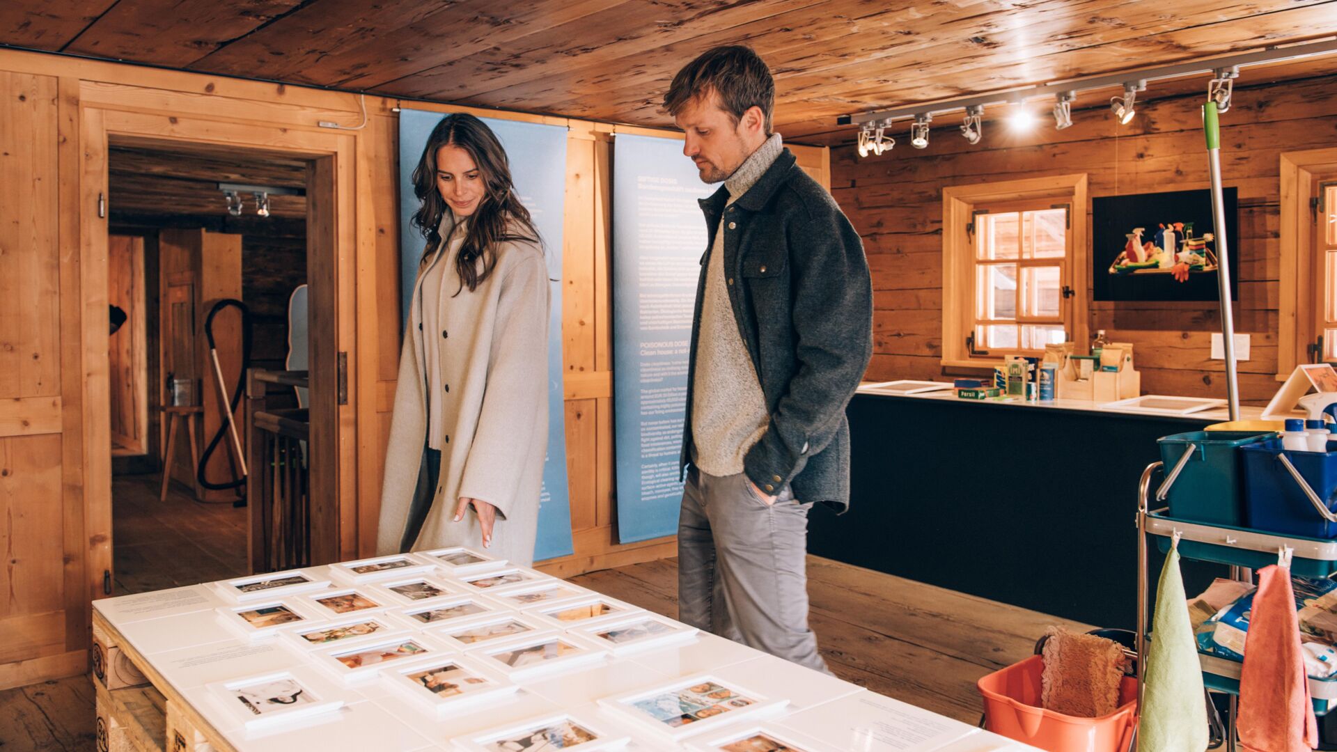 zwei Personen schauen sich gespannt die Ausstellung zu Geschichte, Kunst und Kultur an, in einem urigen, holzigen Ambiente