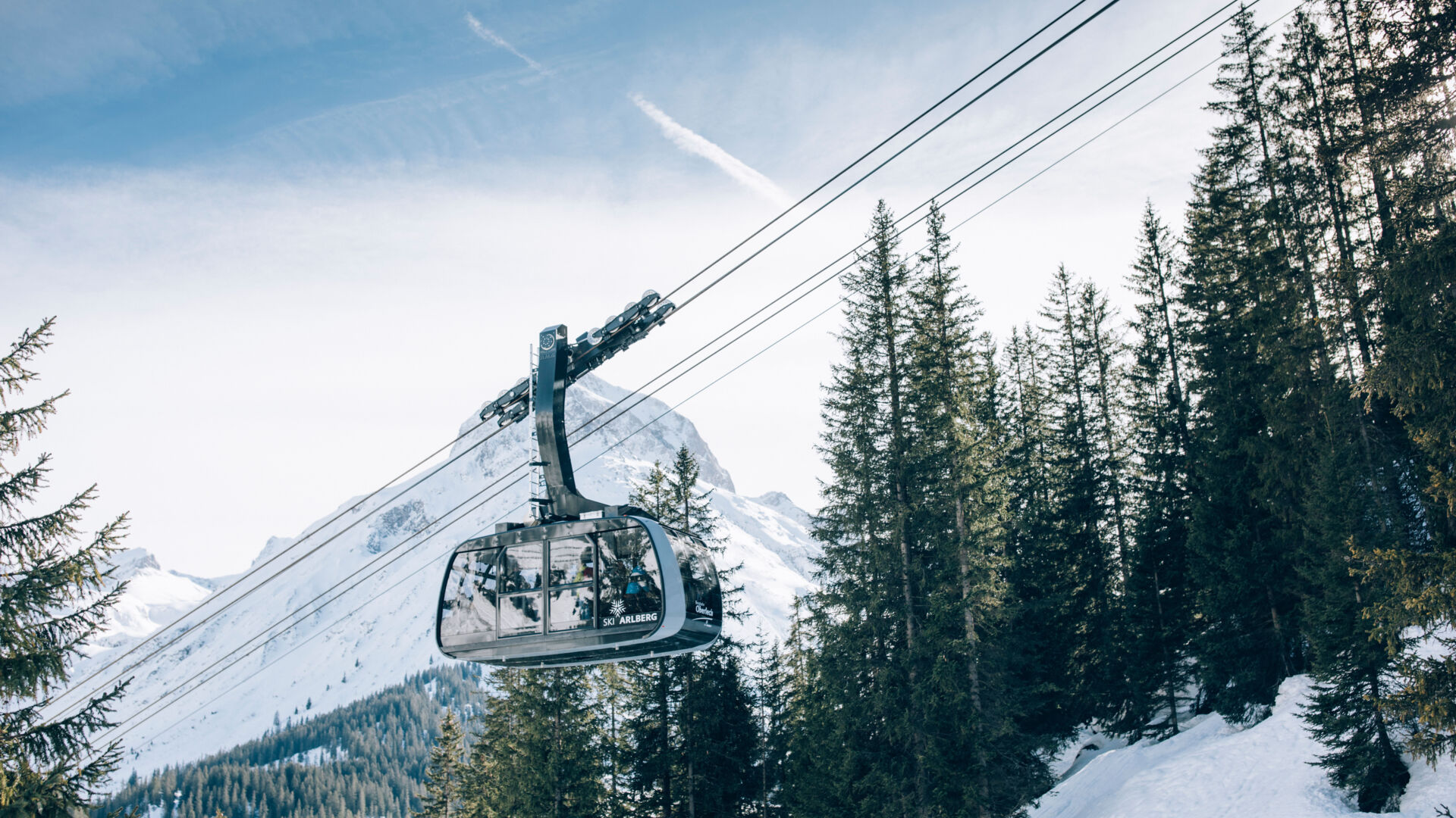 Gondel die zwischen Lech und Oberlech fährt und im Hintergrund ist das Omeshorn und Wald zu sehen