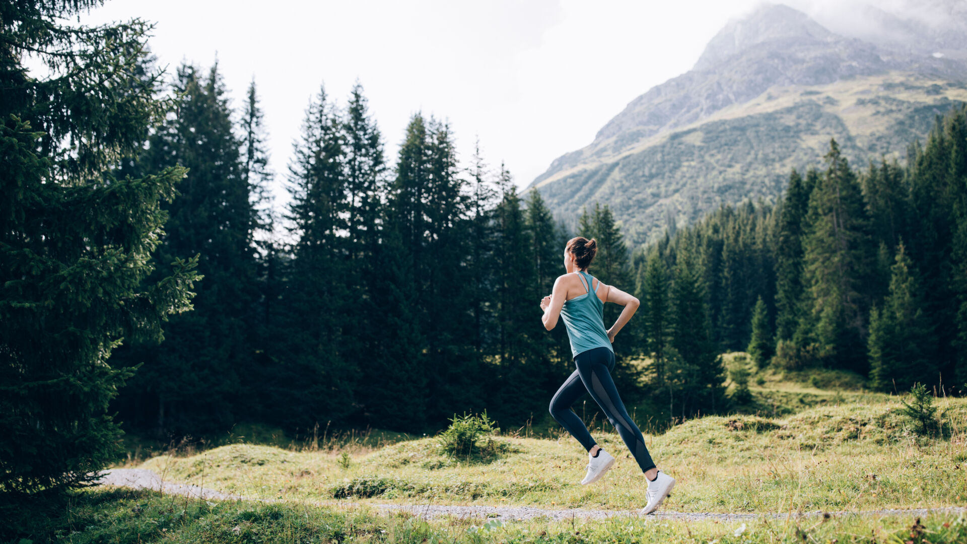 Eine Sportlerin joggt an einem Weg unterhalb des Omeshorns 