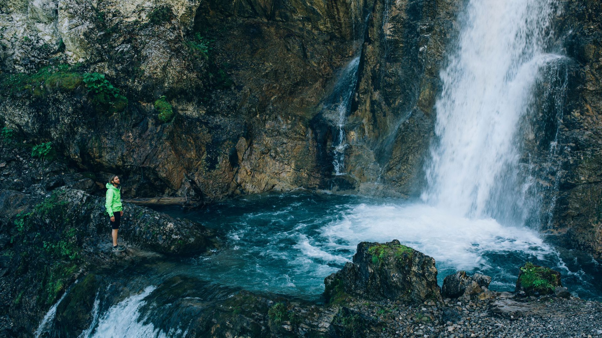 der dunkelblaue Wasserfall plätschert in ein Becken im Felsen