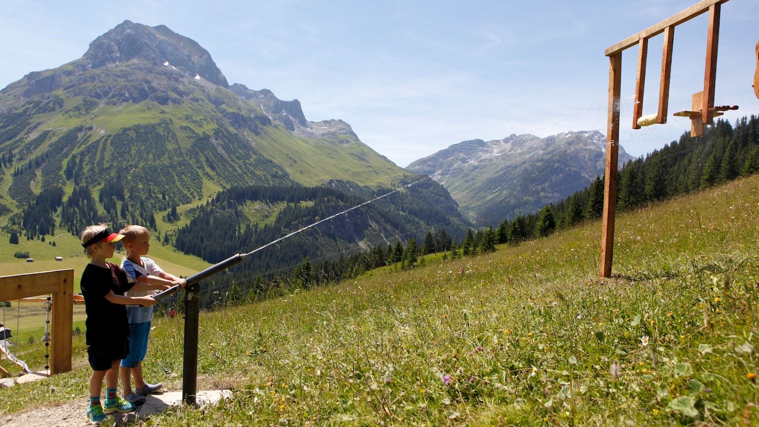 Zwei Jungs spielen am Wasserspielplatz; im Hintergrund ist das Omeshorn zu sehen