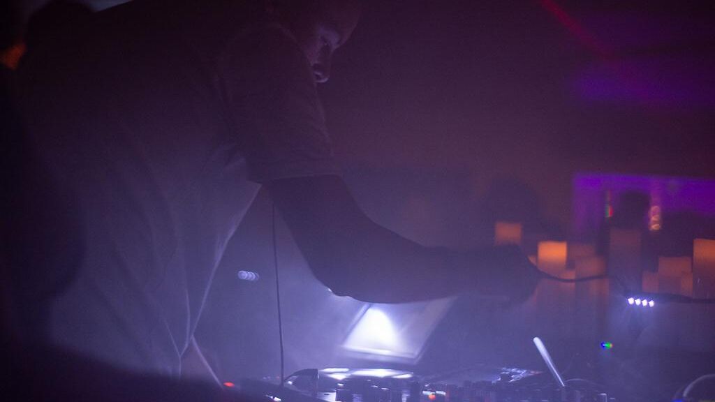 DJ am Pult mischt Musik