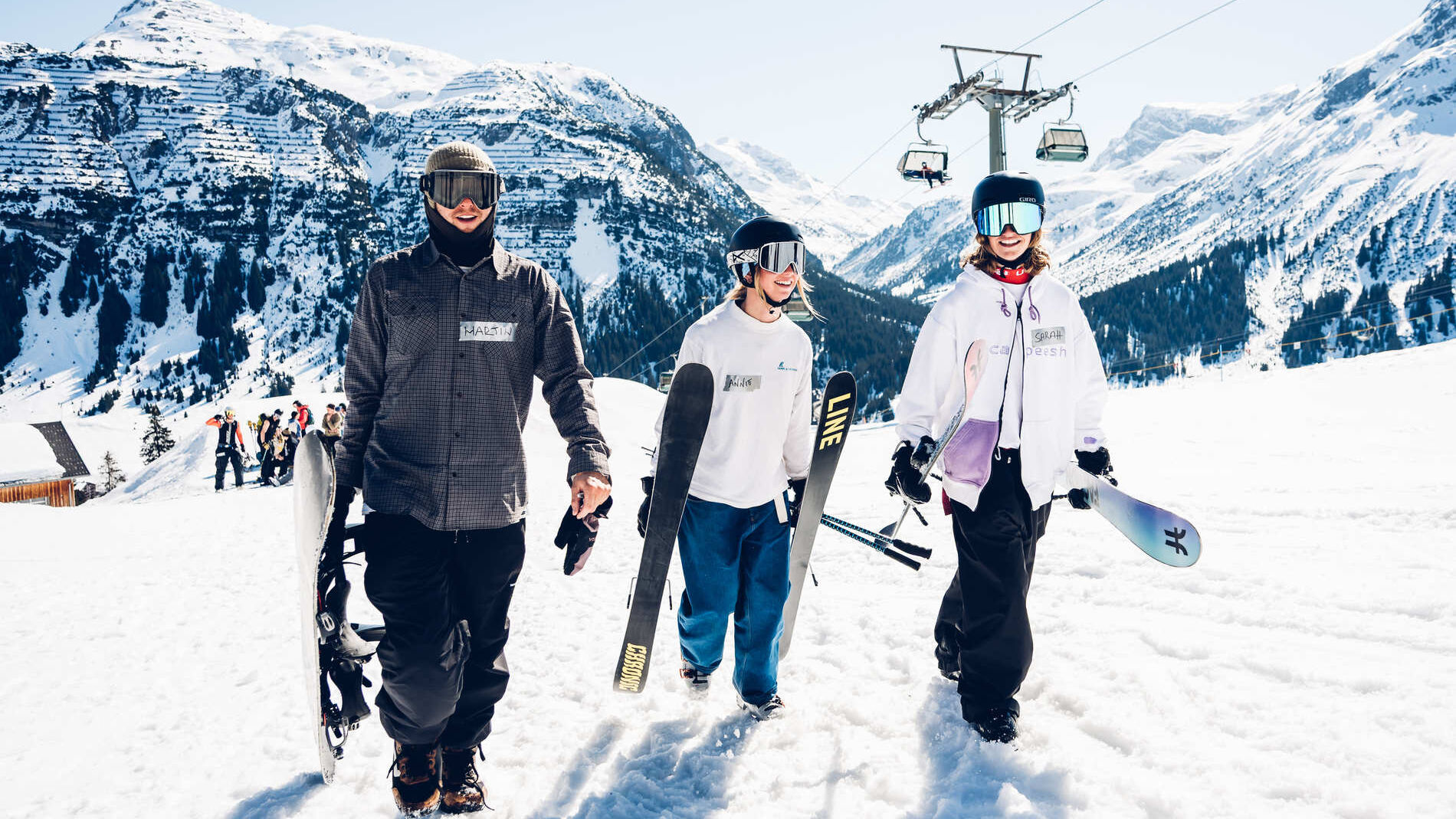 Skifahrer und Snowboarder auf der Piste in Lech vor Bergpanorama