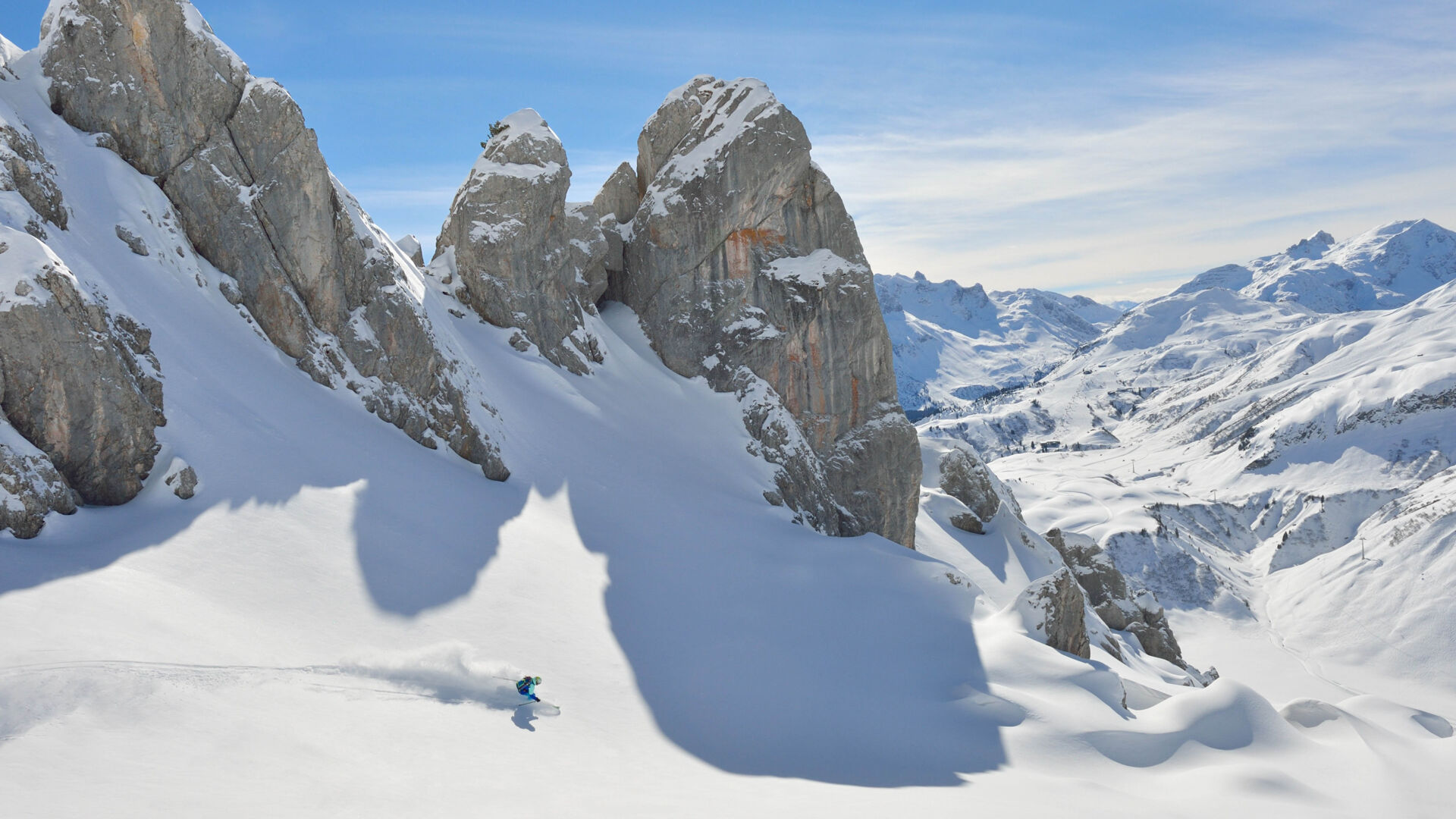 Freerider fährt zwischen kargen Felswänden die Firstline im Neuschnee