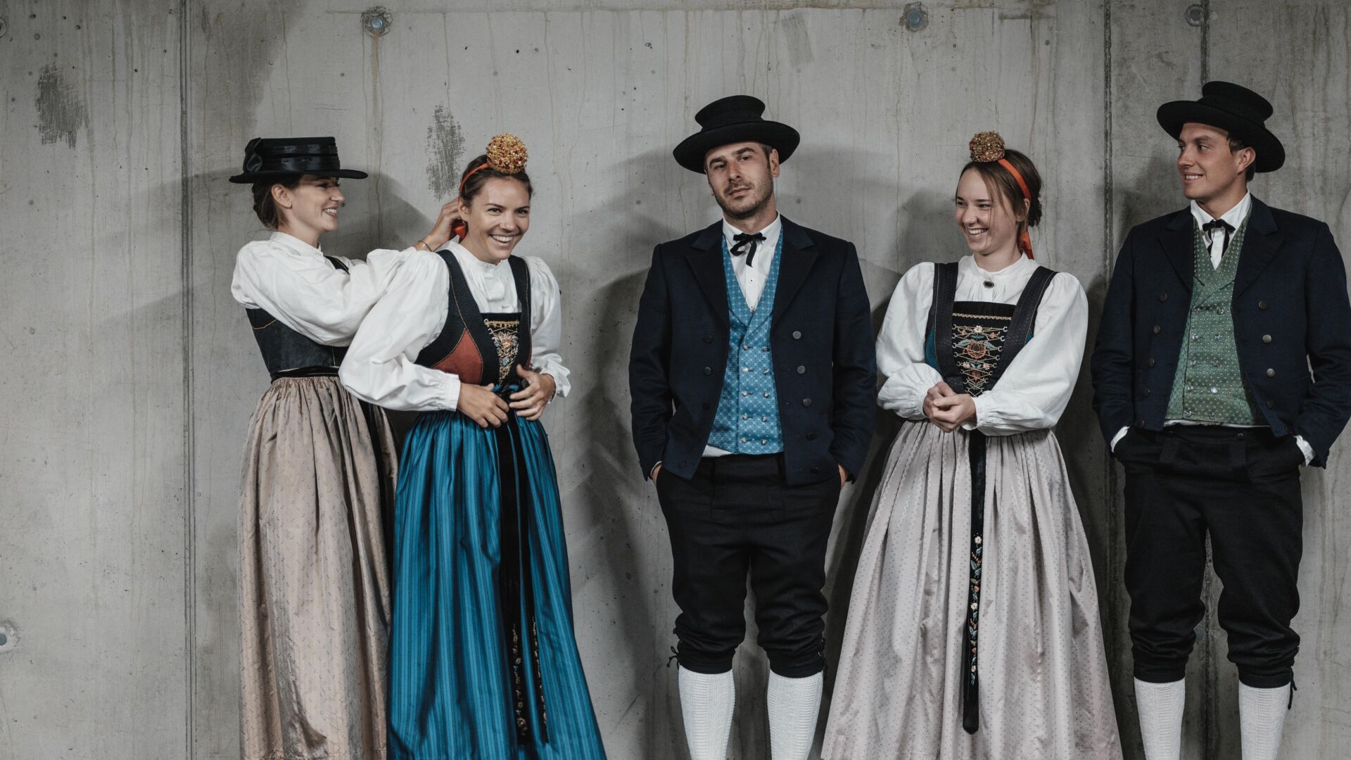 Fuenf junge Menschen in traditioneller Walser Tracht die drei Frauen tragen die Frauentracht die Männer haben zur Tracht noch einen schwarzen Hut auf