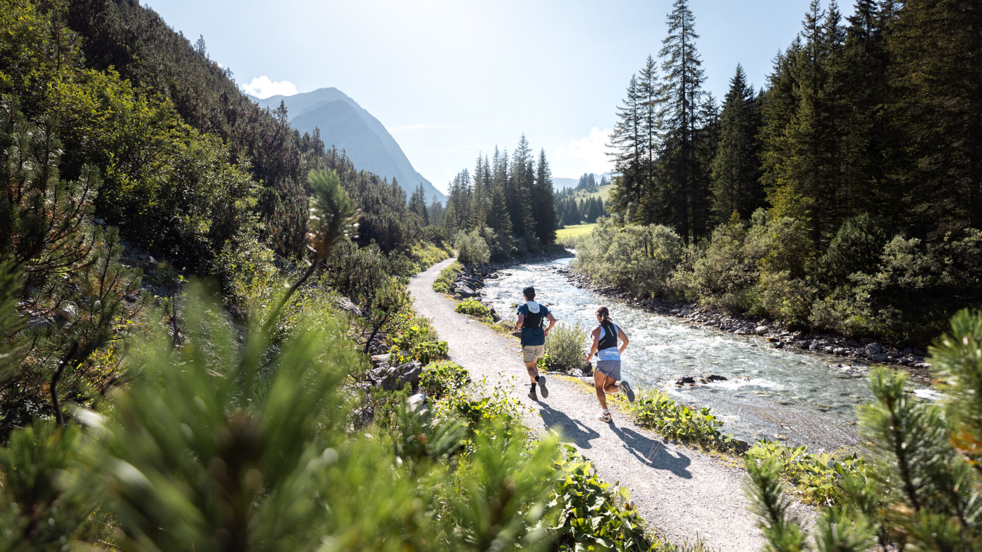 Zwei Trailrunner laufen entlang des Lech am Web nach Zug