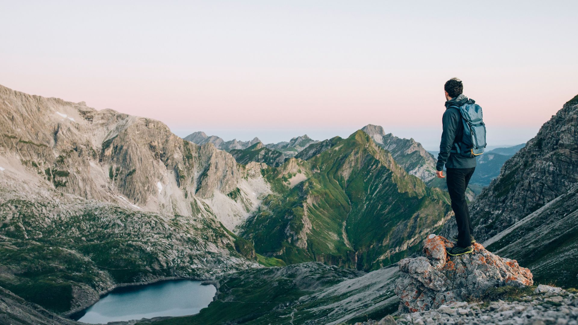 Ein Wanderer blickt hinab auf den Butzensee und genießt du Bergpanorama