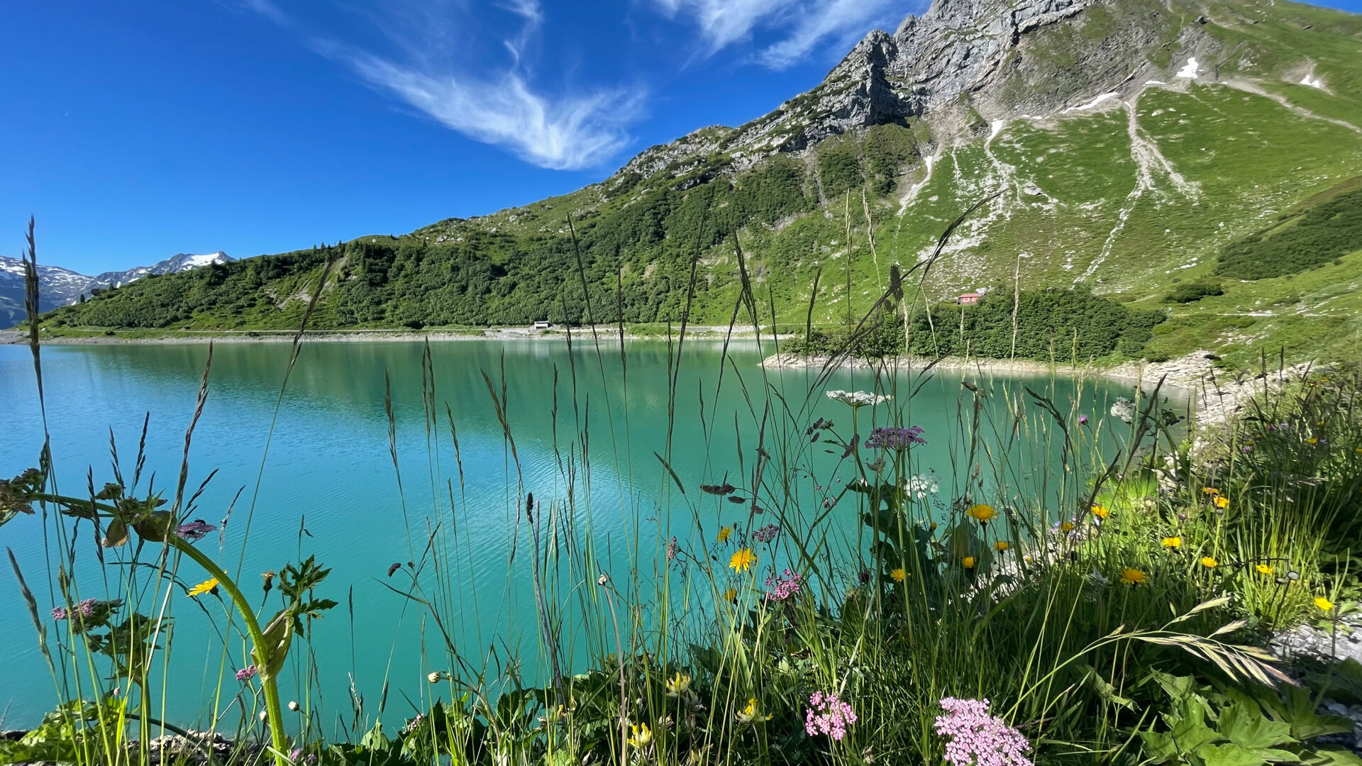 Spullersee blitzt im Sonnenlicht dahinter erhebt sich die Plattnitzer Jochspitze