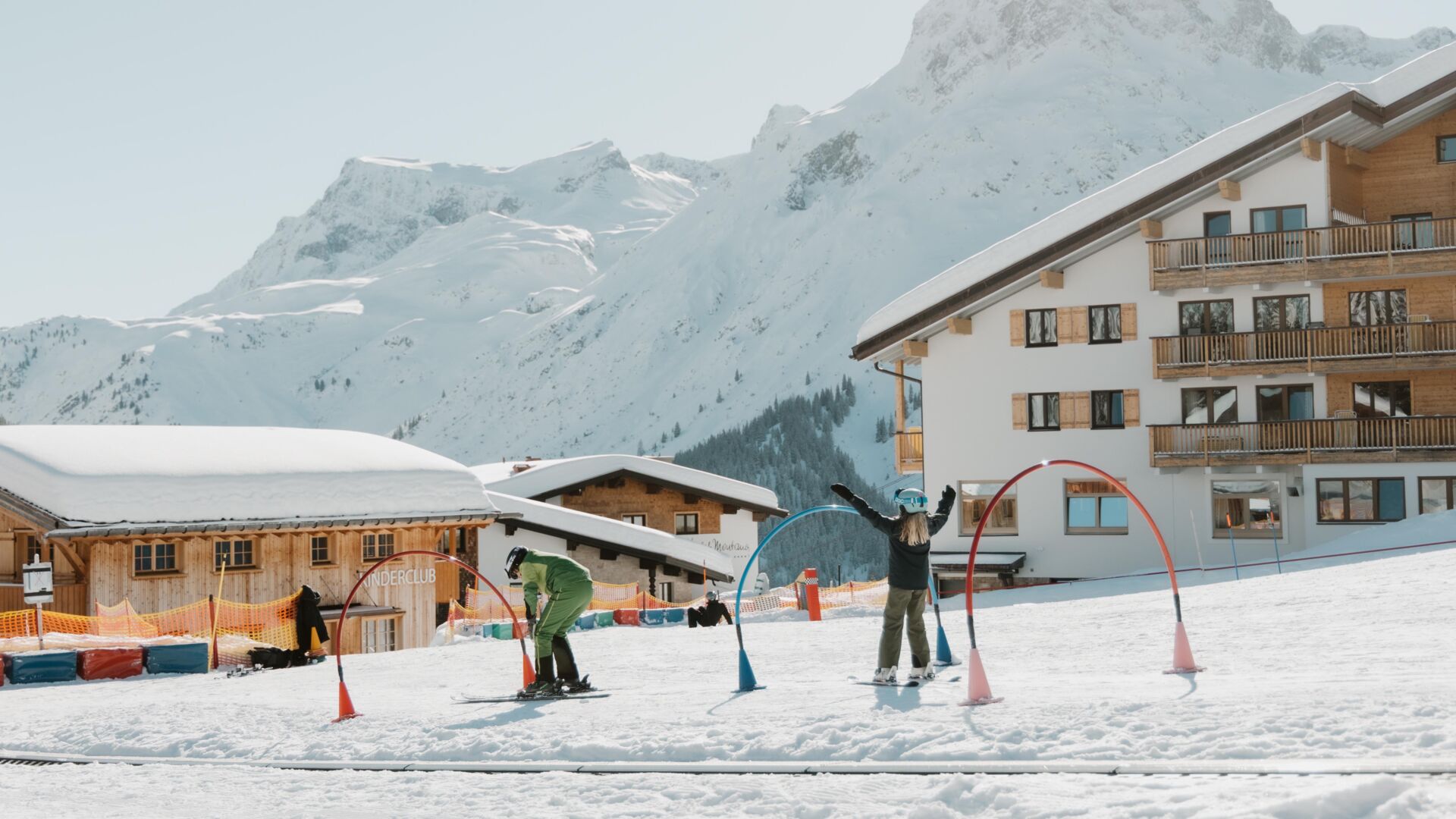 Skilehrerin und Kind haben sichtlich Sapß beim Torbogenfahren im Kinderland
