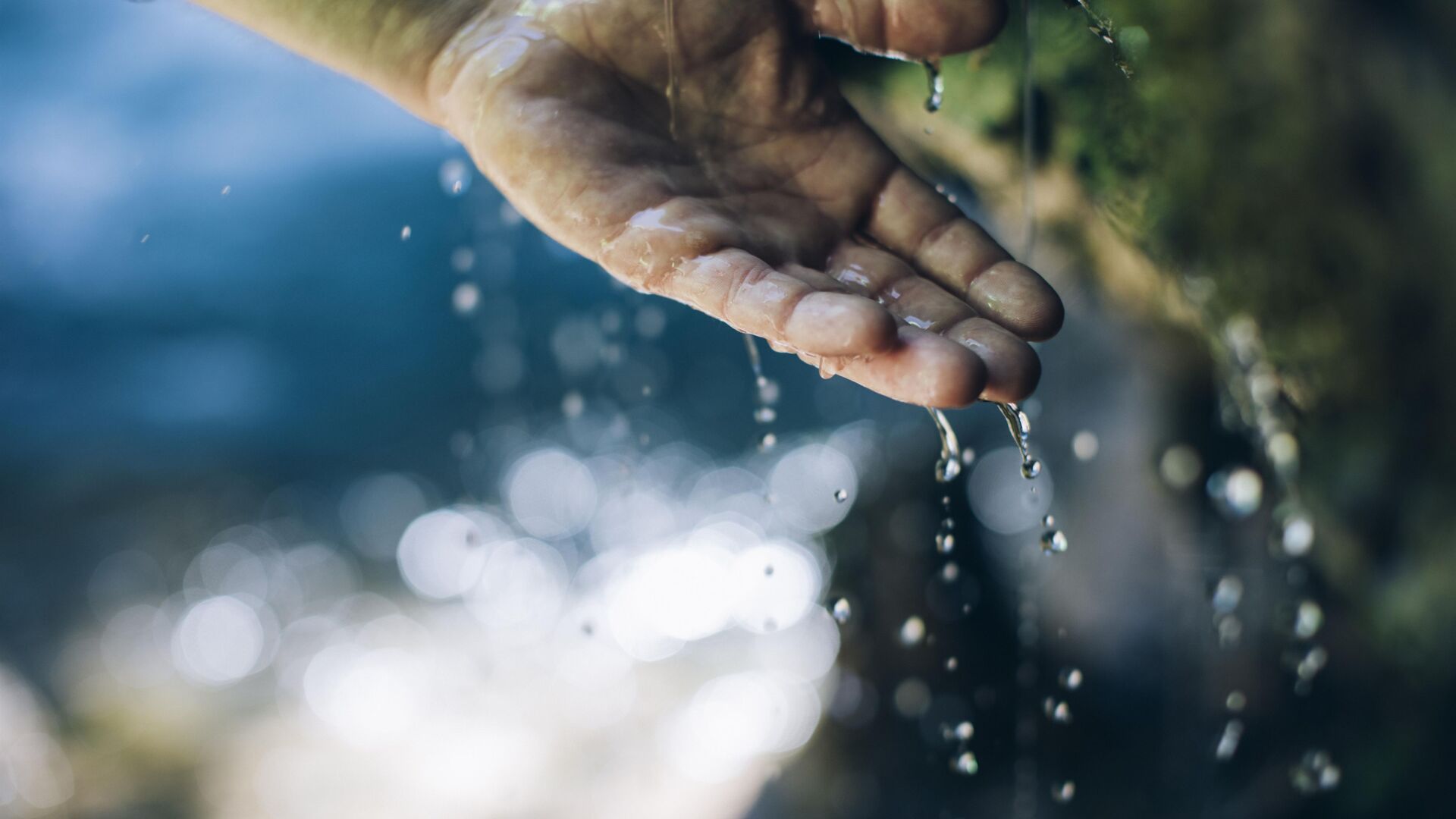 Eine Hand wird von Wassertropfen bedeckt