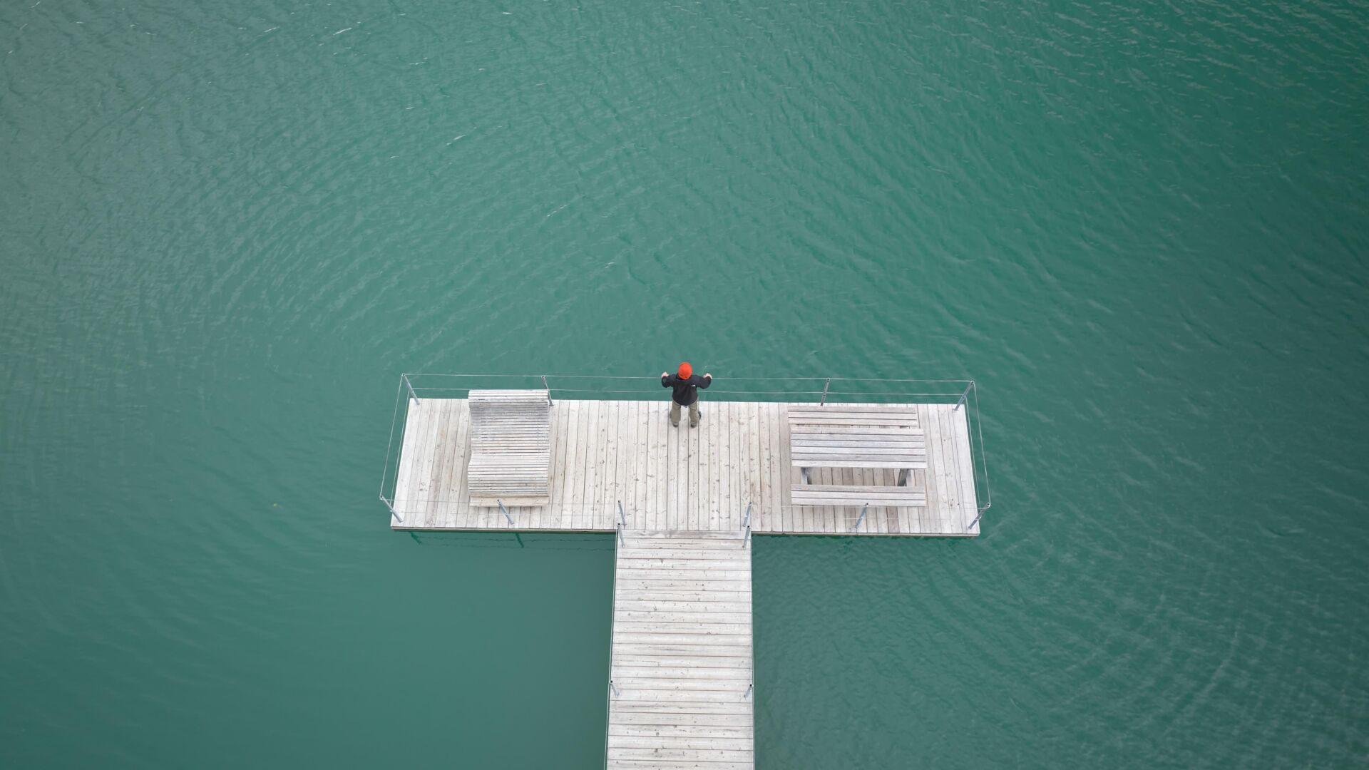 Eine Person steht am Ende des Steeges im Zürser See