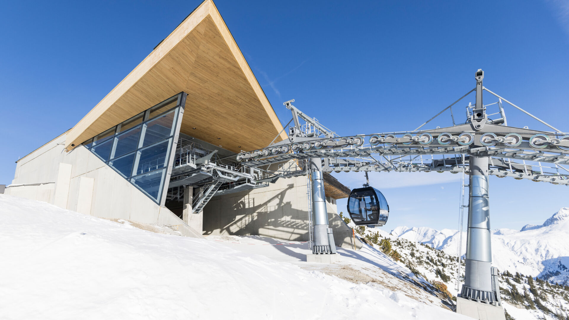 Blick auf die Zugerbergbahn während eine Gondel in die Bergstation einfährt, mit einer winterlichen Landschaft im Hintergrund