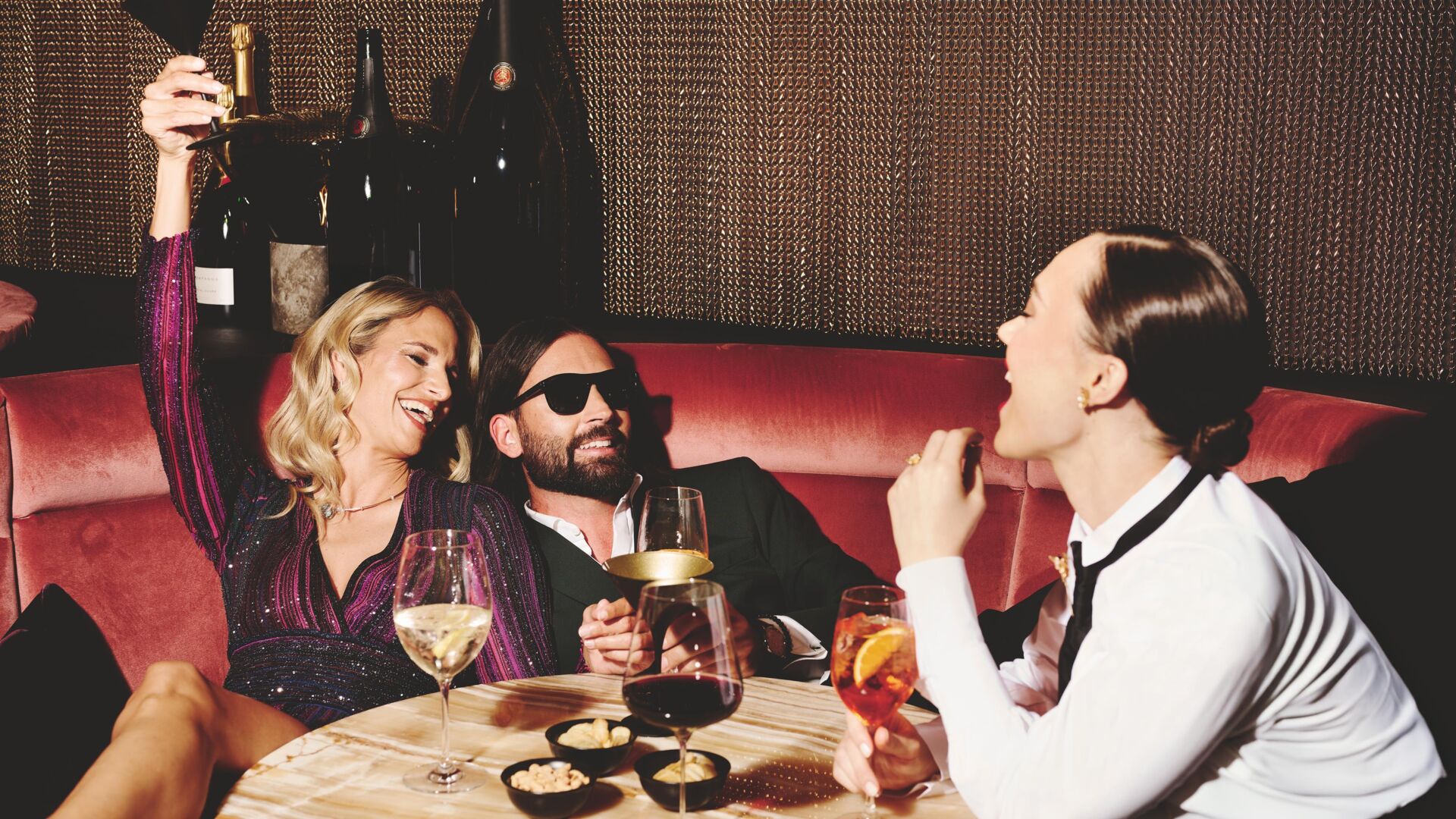 GÃ¤ste feiern in der Abendbar mit Champagner