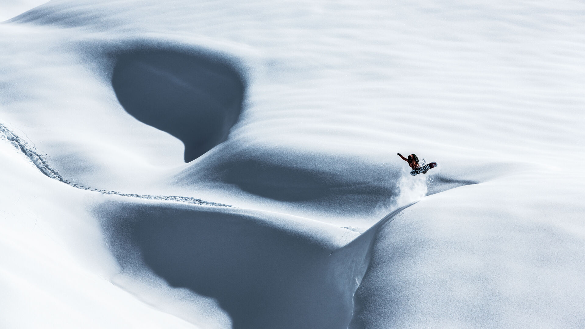 ein Snowboarder fährt durch den Tiefschnee in Vorarlberg