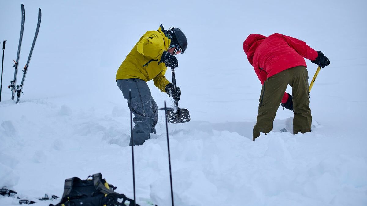 zwei Personen in Skiausrüstung schaufeln den Schnee weg, im Rahmen eines Szenarios einer Lawinenverschüttetensuche 