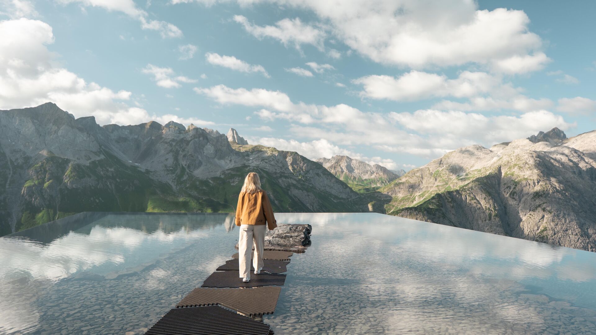 Frau auf Felsen in einem spiegelnden Bergsee vor schroffem Alpenpanorama.