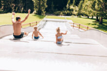 Spass auf der Wasserrutsche im Waldschwimmbad Lech waldschwimmbad-lech-sommer-wasserrutsche-vorarlberg