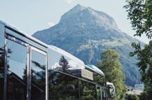 Blauer Ortsbus mit Sommerpanorama im Sommer Ortsbus-Lech-mit-Blick-auf-das-Omeshorn
