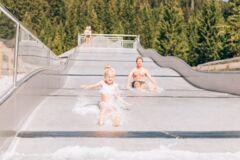 Zwei Kinder rutschen auf der Wasserrutsche