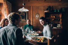Freunde sitzen gemeinsam am runden Tisch und genießen freudige Momente beim Essen miteinander