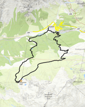 Wanderin steht am Berg in der Morgensonne und blickt in die Ferne