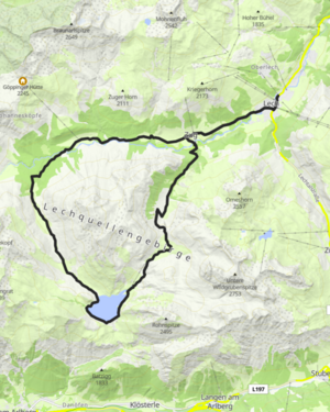 Blick über das türkise Wasser des Spullersees auf die umliegenden Berge