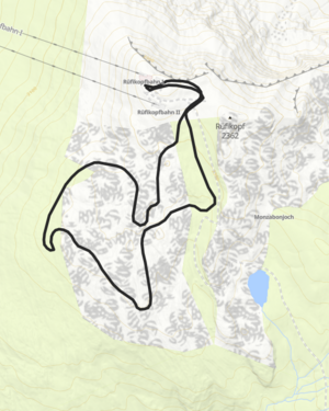 eine gro&szlig;e Schneeflockentafel kennzeichnet den Winterwanderweg am R&uuml;fikopf, im Hintergrund sieht man die schneebedeckten Berge