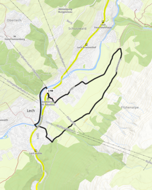 ein junges Paar wandert &uuml;ber eine Wiese in Richtung B&uuml;rstegg, im Hintergrund ragt das Omeshorn in die H&ouml;he