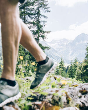 ein Mann l&auml;uft &uuml;ber den Wanderweg, im Hintergrund sieht man die Bergkulisse mit dem Omeshorn