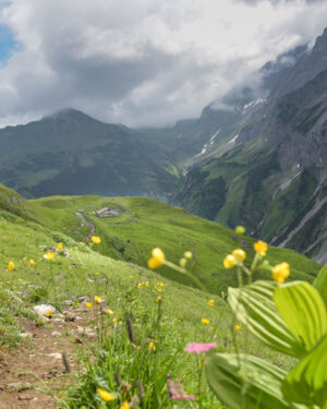 Satte gr&uuml;ne Wiesen und ein Bergpanorama das von dunklen Wolken getr&uuml;bt wird