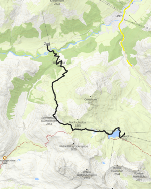 ein Mann läuft über den Wanderweg, im Hintergrund sieht man die Bergkulisse mit dem Omeshorn