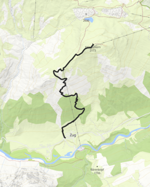 ein junges Paar wandert &uuml;ber eine Wiese in Richtung B&uuml;rstegg, im Hintergrund ragt das Omeshorn in die H&ouml;he