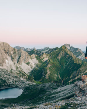 Ein Wanderer blickt hinab auf den Butzensee und genießt du Bergpanorama