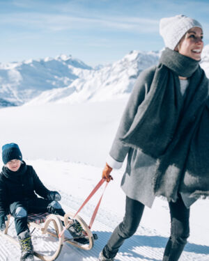 Winterwandern mit der Familie am Wanderweg Richtung Rüfikopf mit Schlitten durch die idyllisch verschneite Berglandschaft in Vorarlberg