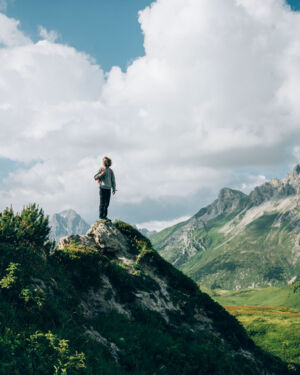 ein Wanderer steht auf einem Felsvorsprung und genießt die Aussicht auf die Gipslöcher und das traumhafte Bergpanorama im Hintergrund