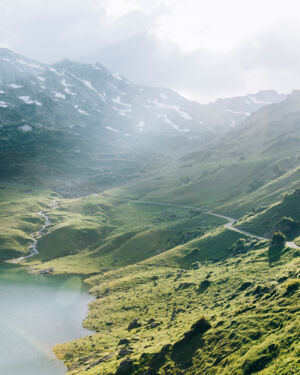 ein Wanderweg f&uuml;hrt durch die gr&uuml;nen Bergwiesen &uuml;ber dem Formarinsee vorbei