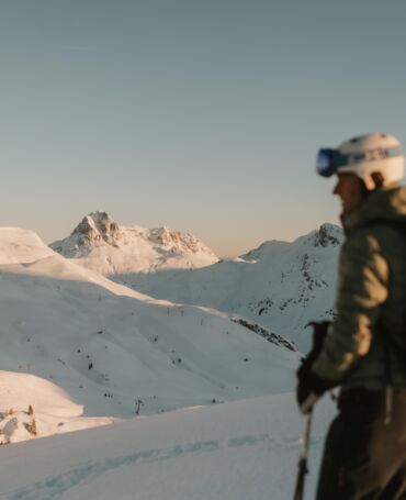 Skifahrerer blickt über das tief verschneite Skigebiet und macht sich bereit zur Abfahrt